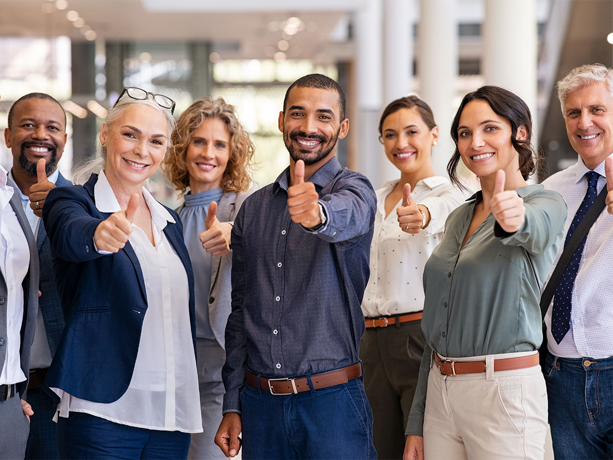 Group of successful business people showing thumbs up Symbolbild für Best Practice-Sharing mit einer Gruppe von Personen